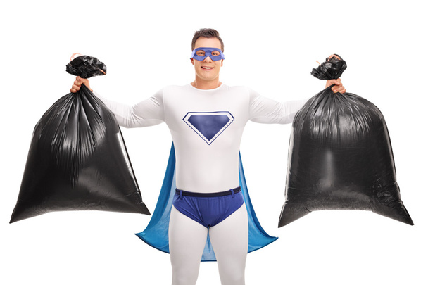 Superhero holding two trash bags  - Foto, imagen