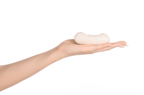 Hygiene and health care topic: a woman's hand holding a white bar of soap isolated on white background in studio - Photo, image