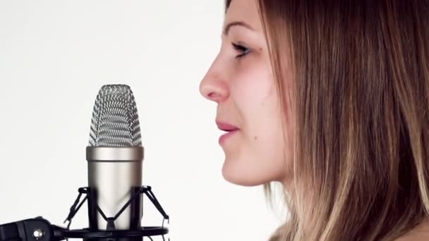 Gyönyörű lány énekel a stúdióban mikrofon. - Felvétel, videó