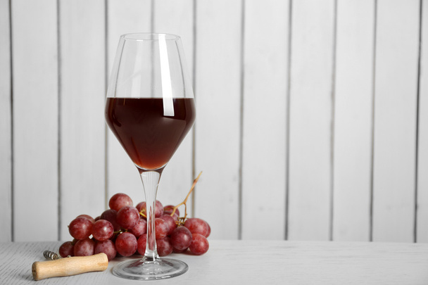 Red wine with grape on wooden wall background - Fotografie, Obrázek
