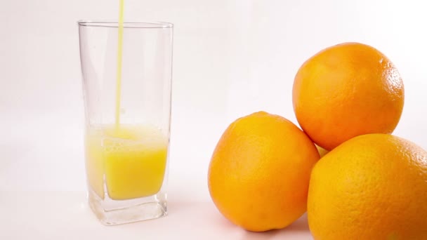 jugo de naranja vertiendo en el vaso - Imágenes, Vídeo