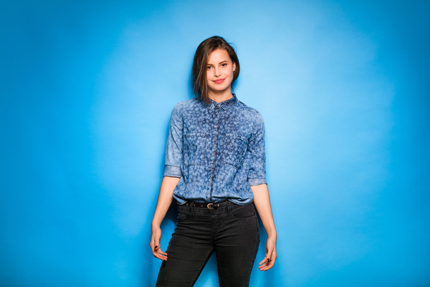 young woman casual dressed on blue background - Fotó, kép