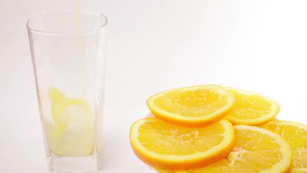 sinaasappelsap dat in glas stroomt - Video