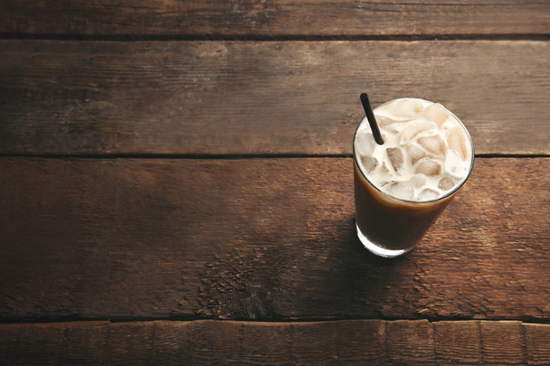 Cup of ice coffee with straw on wooden background - Zdjęcie, obraz