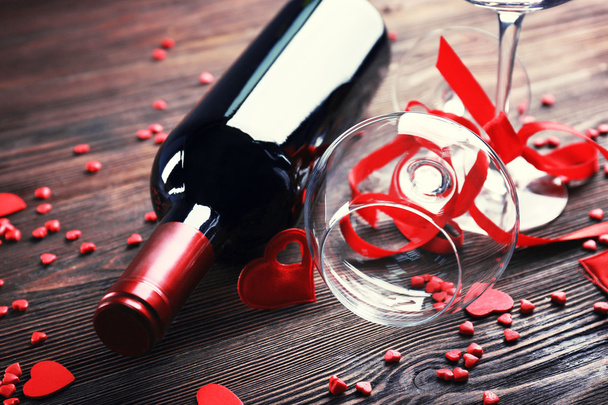 Wine bottle and glasses with handmade hearts on wooden background, close up - Foto, Bild