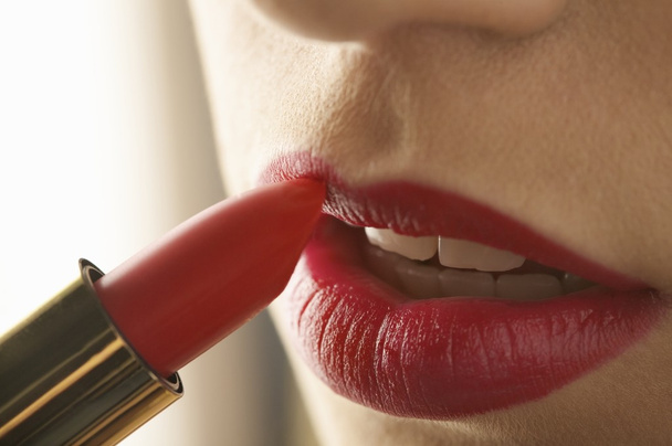 Frau trägt roten Lippenstift auf - Foto, Bild