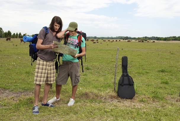 backpackers on meadow with paper map  - Photo, Image