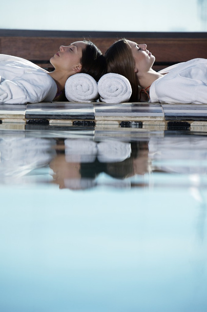  women lying near swimming pool - 写真・画像