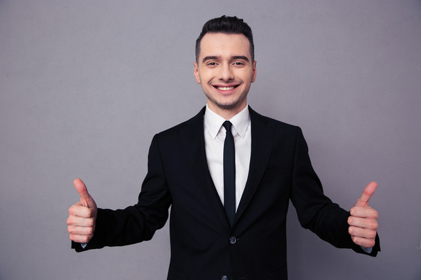 Smiling businessman showing thumbs up - Foto, immagini