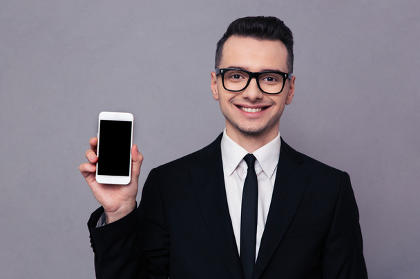 Smiling businessman shoing blank smartphone screen  - Foto, Imagem