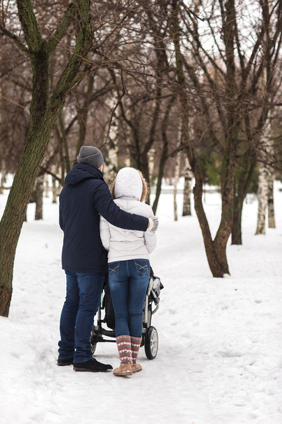 Happy young family walking in the park in winter - 写真・画像
