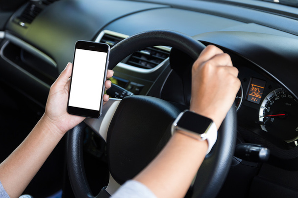 hand holding phone white screen and driving car - Foto, afbeelding
