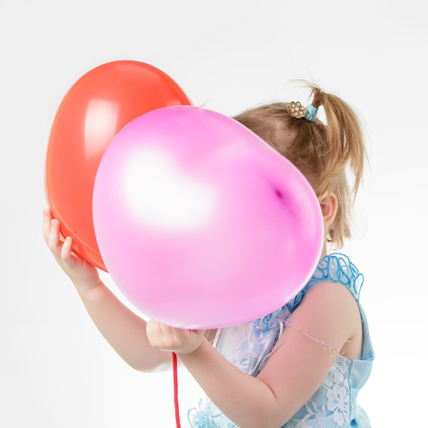 Menina em vestido azul segurando um balão
 - Foto, Imagem