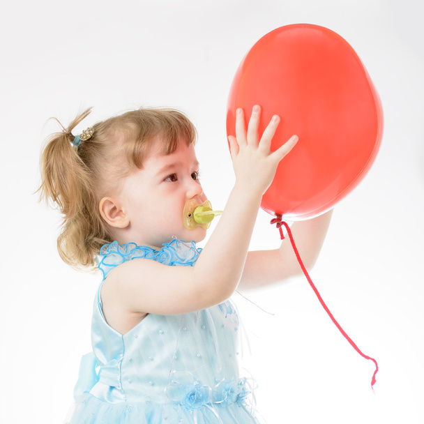 Little girl in blue dress holding a balloon - Фото, зображення