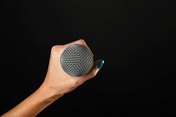 Женщина рука с микрофоном изолированы на черный
 - Фото, изображение
