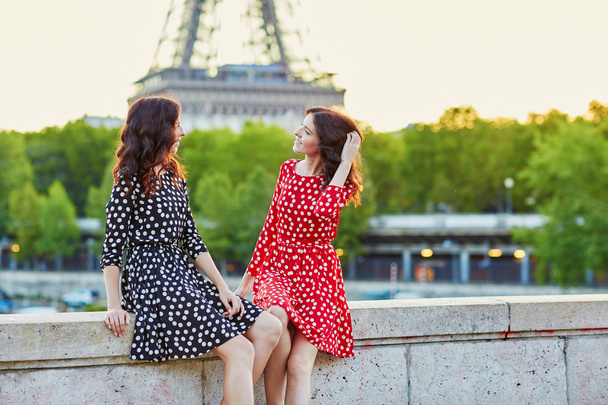Beautiful twin sisters in front of the Eiffel tower in Paris - Zdjęcie, obraz