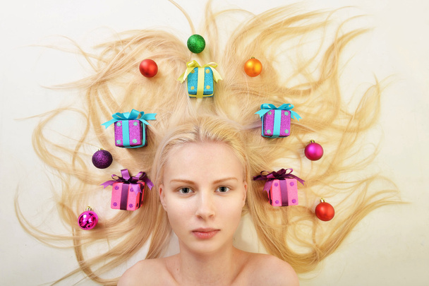 Blonde vrouw met kerstboom lichten - Foto, afbeelding