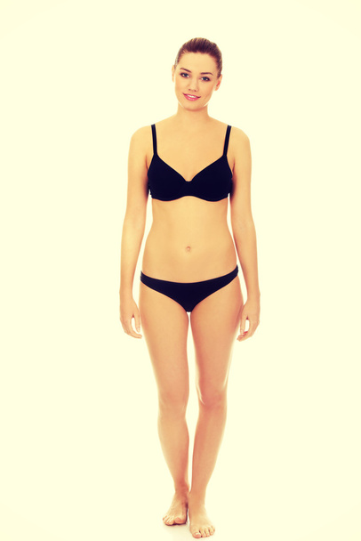 Happy woman standing in bikini. - 写真・画像