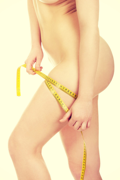 Slim woman measuring her thigh. - Fotografie, Obrázek