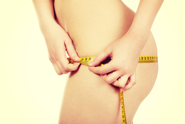 Slim woman measuring her hips. - Foto, Imagen