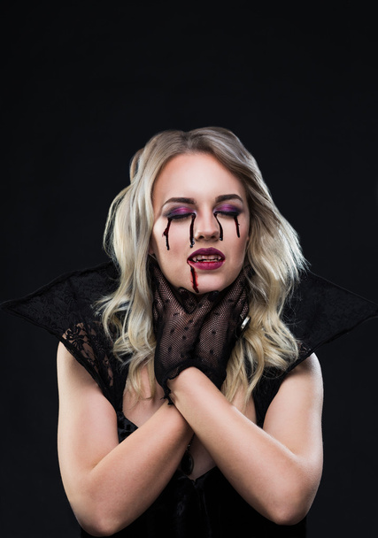 Beautiful blonde girl vampire is strangling herself - Photo, Image