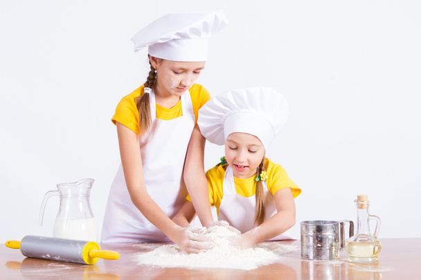 Two girls kneaded the dough, flour, egg - Фото, зображення