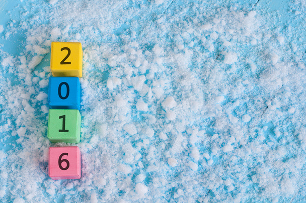 Neujahr 2016 auf Spielzeug-Holzwürfeln. auf Schnee Hintergrund - Foto, Bild