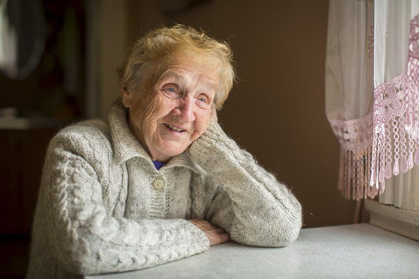 ältere Frau sitzt am Fenster - Foto, Bild