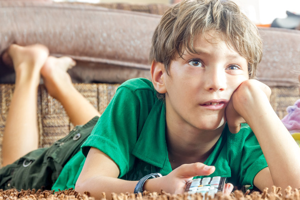 крытый портрет мальчика, смотрящего телевизор дома
 - Фото, изображение