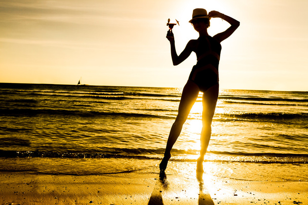 beztroski Kobieta tańczy w zachód słońca na plaży. vita wakacje - Zdjęcie, obraz