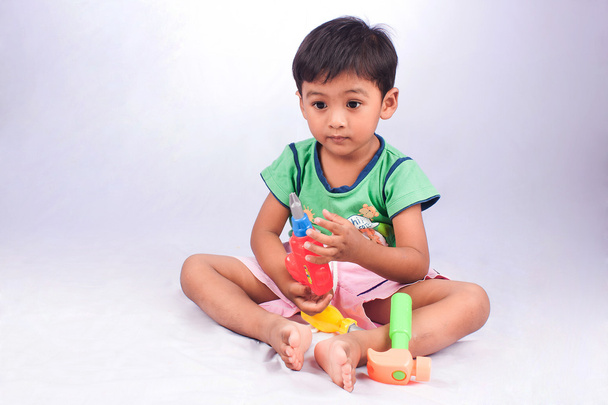 lindo niño jugar herramienta plástico juguete sobre fondo blanco
 - Foto, Imagen