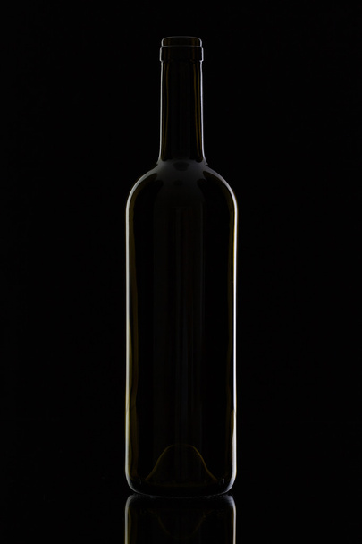 Empty bottle on the black glass  - Foto, afbeelding