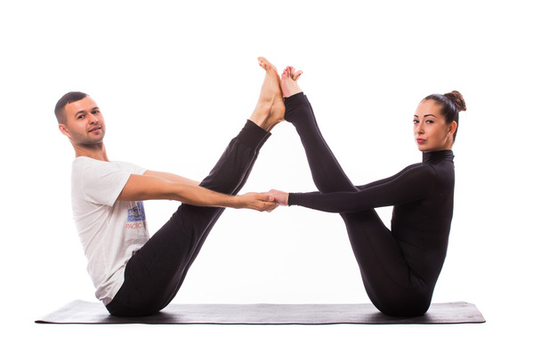 Joven pareja sana en posición de yoga sobre fondo blanco
 - Foto, Imagen