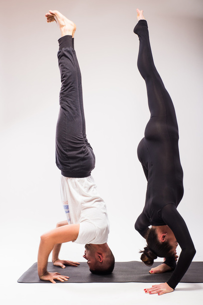Young healthy couple in yoga position on white background - Foto, imagen