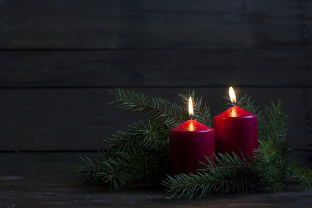 Різдвяні свічки та вогні. Дві палаючі свічки з вафлями та гілкою ялиці над дерев'яним тлом, натюрморт
 - Фото, зображення