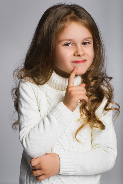 Portrait of little girl thinking, over a gray background - Foto, afbeelding