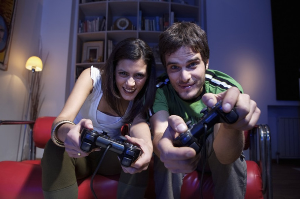 jovem casal brincando com joysticks
 - Foto, Imagem