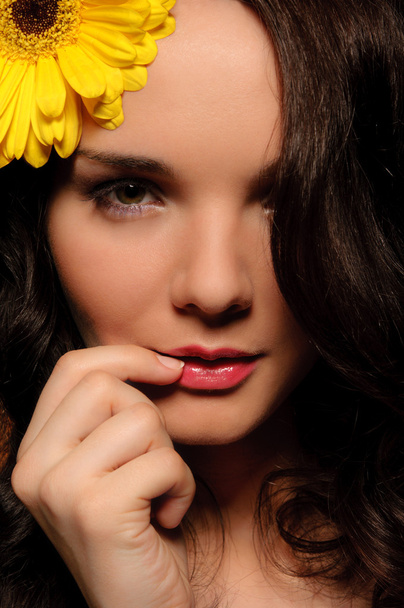 Beautiful woman with yellow flower in her hair - Foto, afbeelding