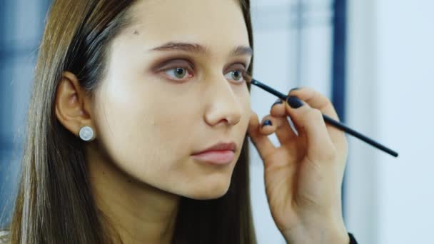 Young woman apply makeup around the eyes - Filmagem, Vídeo