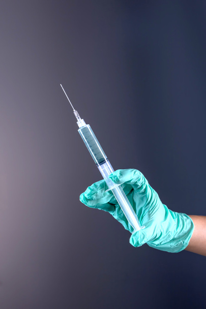 Holding a syringe and needle. - Photo, Image
