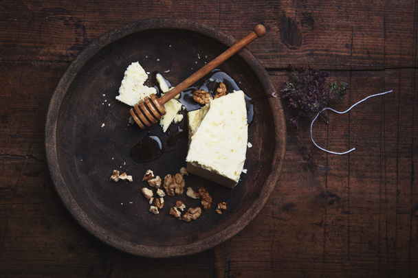 Sheep cheese with honey and walnuts on a old wooden table - Foto, Imagen
