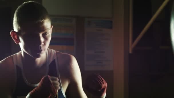 Mladý boxer trénink v posilovně s boxovací pytel - Záběry, video