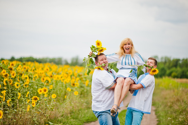 Happy family having fun on sunflowers - Photo, Image