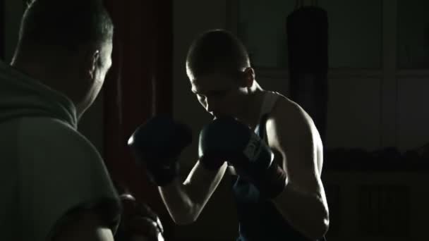 Nyrkkeilyvalmentaja kouluttaa nuorta nyrkkeilijää.
 - Materiaali, video