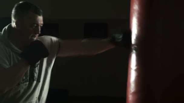 Η πυγμαχία προπονητή χτυπάει κόκκινο σάκο ζουμπάρισμα - Πλάνα, βίντεο
