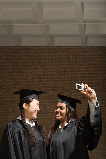Dos mujeres graduadas tomando una fotografía
 - Foto, imagen