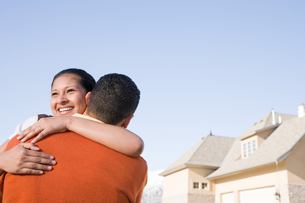 Ένα ζευγάρι αγκαλιάζει έξω από το νέο τους σπίτι - Φωτογραφία, εικόνα
