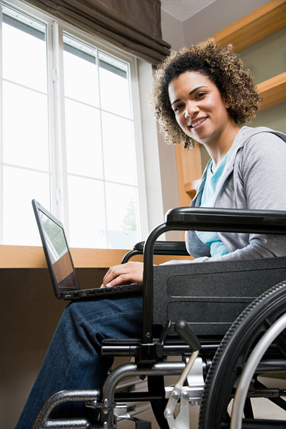 Niepełnosprawnych kobieta przy użyciu komputera przenośnego - Zdjęcie, obraz
