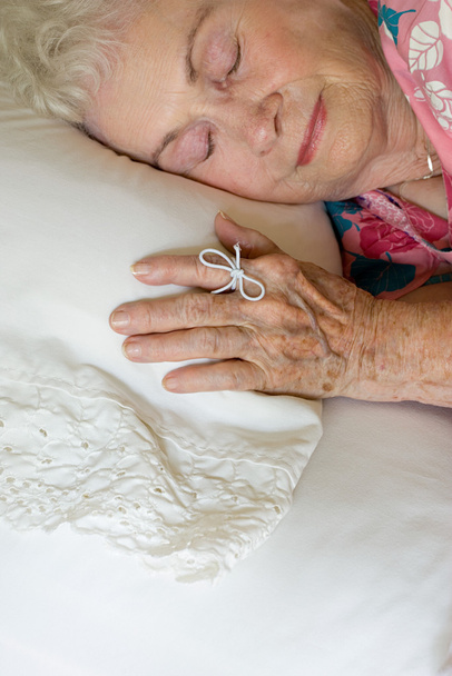 Ηλικιωμένη γυναίκα που κοιμάσαι με συμβολοσειρά στο δάχτυλό της - Φωτογραφία, εικόνα