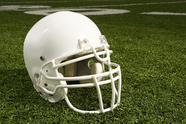 Шлем на американском футбольном поле
 - Фото, изображение